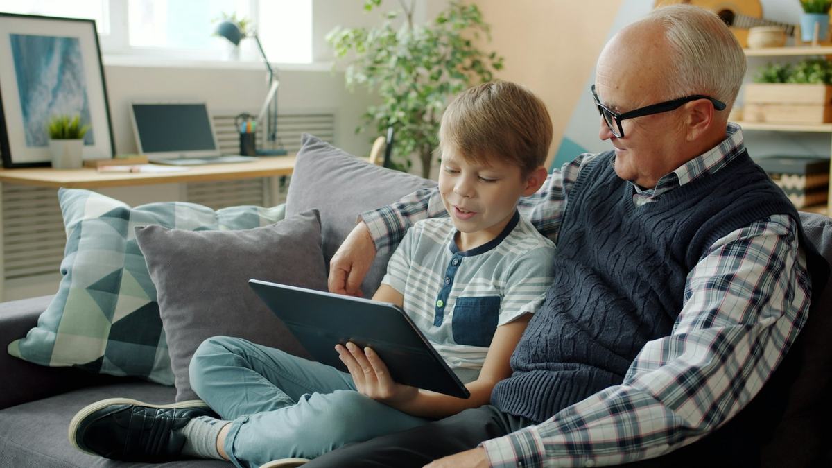 Nonno e nipote che guardano insieme lo schermo di un tablet